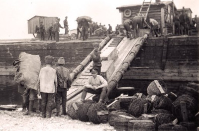 Canadian_Gunner_Supervises_Prisoners_Loading_a_Barge_in_Yemetskoe_in_May_1919.jpg